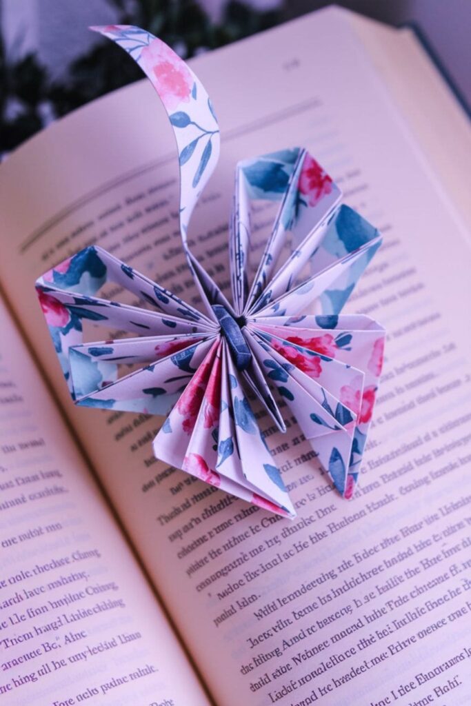 A creative bookmark crafted from floral-patterned origami paper, folded into intricate shapes like hearts or butterflies, adding a charming handmade touch to reading accessories