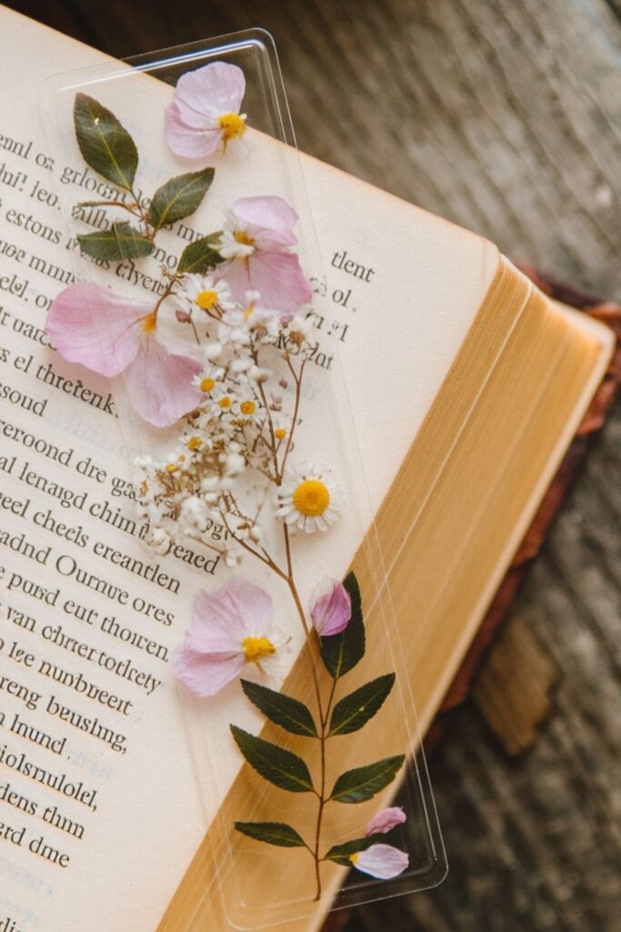 A delicate bookmark made with real pressed flowers and leaves, laminated or glued onto a sturdy base, showcasing a natural and timeless beauty