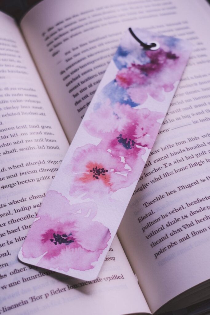 A dreamy bookmark featuring hand-painted watercolor flowers in soft pastel tones, with delicate blending of colors creating a gentle and artistic aesthetic