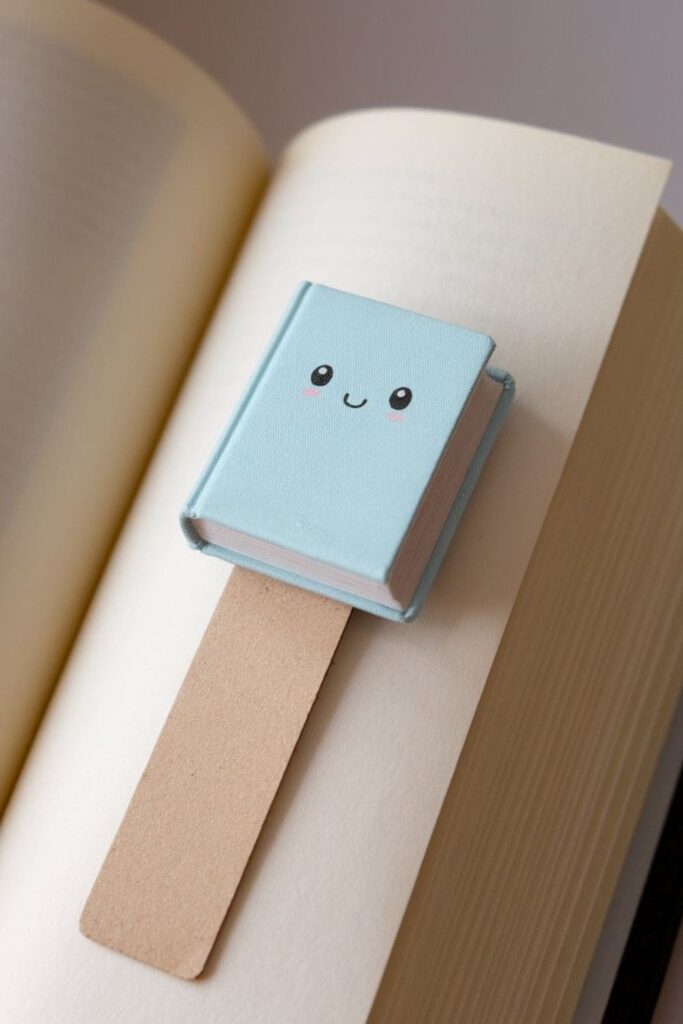 A tiny handmade book attached to a thin ribbon, with realistic pages and a miniature cover, perfect for book lovers who enjoy adorable crafts